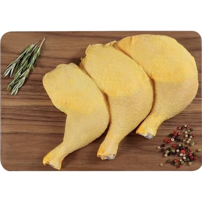 Piernas y muslos de pollo sobre tabla de madera